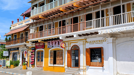 Colourful heritage-style building façade with balconies and shopfronts.