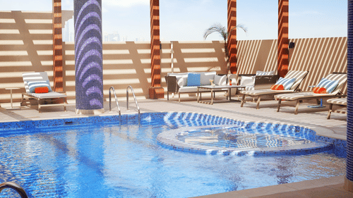 an overview of a swimming pool with loungers on the side - La Maison Hotel, Doha