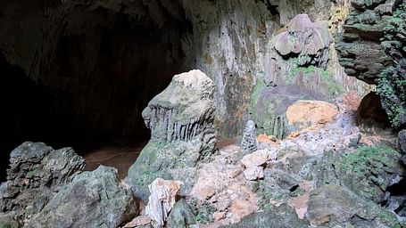 An overview of a limestone cave with stalagmites and stalactites seen inside.