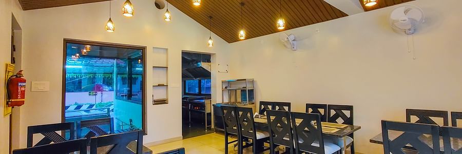 A brightly lit indoor dining area with wooden ceilings and neatly arranged tables - MGM Whispering Meadows
