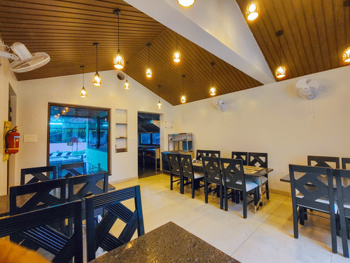 A brightly lit indoor dining area with wooden ceilings and neatly arranged tables - MGM Whispering Meadows