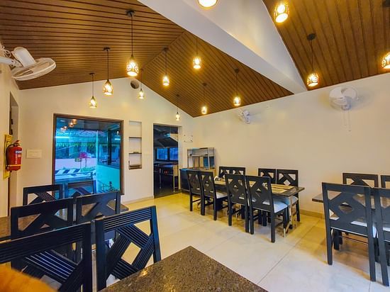 A brightly lit indoor dining area with wooden ceilings and neatly arranged tables - MGM Whispering Meadows