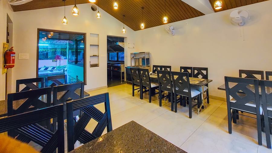 A brightly lit indoor dining area with wooden ceilings and neatly arranged tables - MGM Whispering Meadows