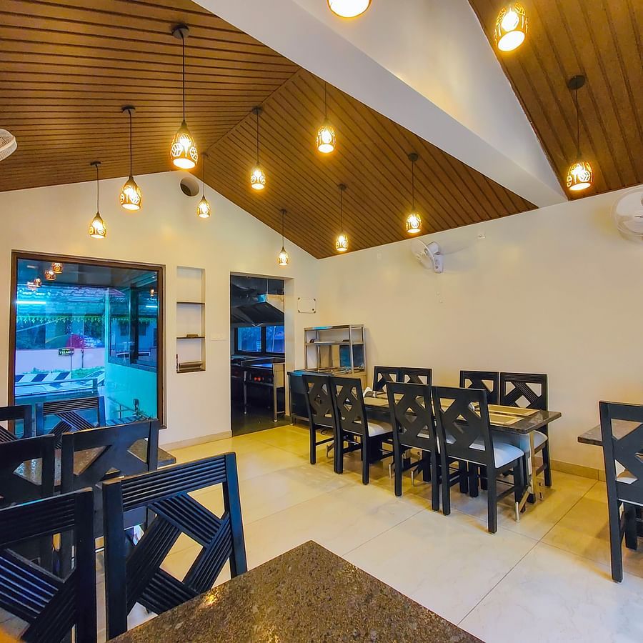 A brightly lit indoor dining area with wooden ceilings and neatly arranged tables - MGM Whispering Meadows