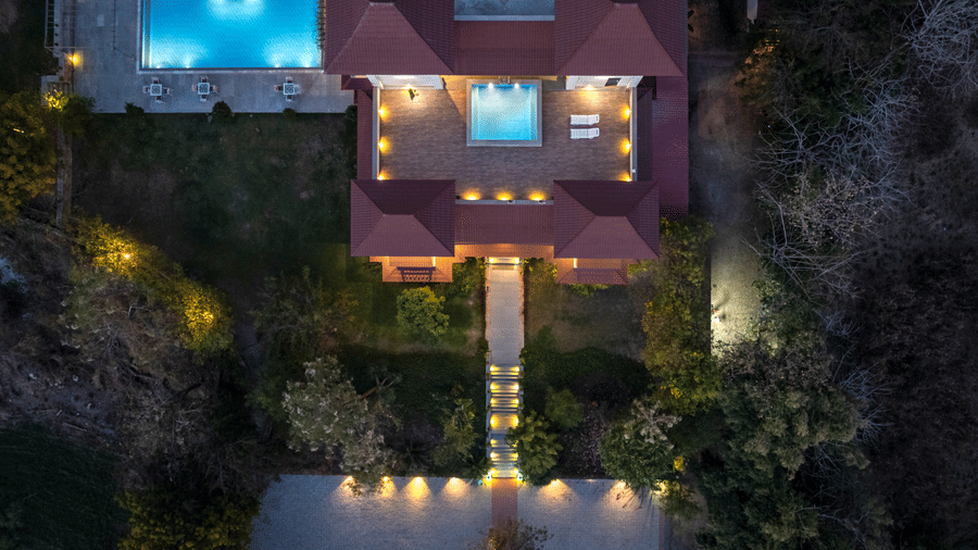 Top view of The Hunting Lodge, Udaipur, showcasing the illuminated pathways and exterior and 2 swimming pools.