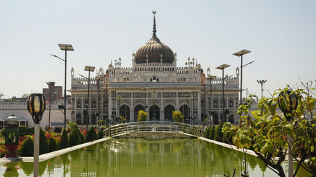 Chota Imambara, one of the things to visit in Lucknow, with an ornate dome and arches stands beyond a landscaped garden and reflective pond