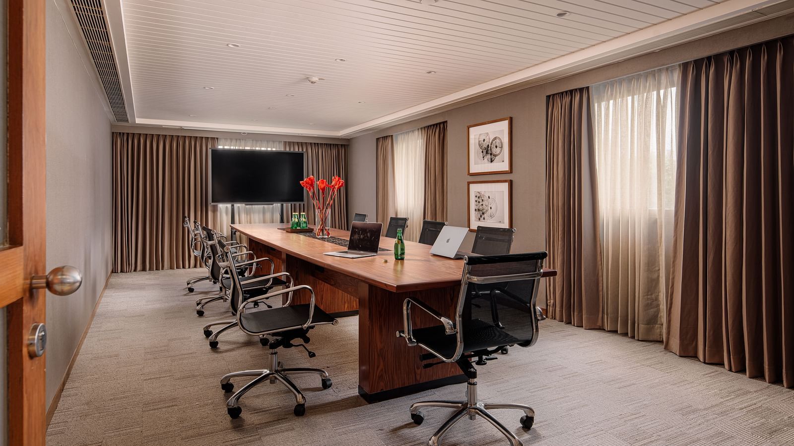 A well-appointed boardroom with a large conference table, equipped for productive meetings at The Raintree, St. Mary's Road.