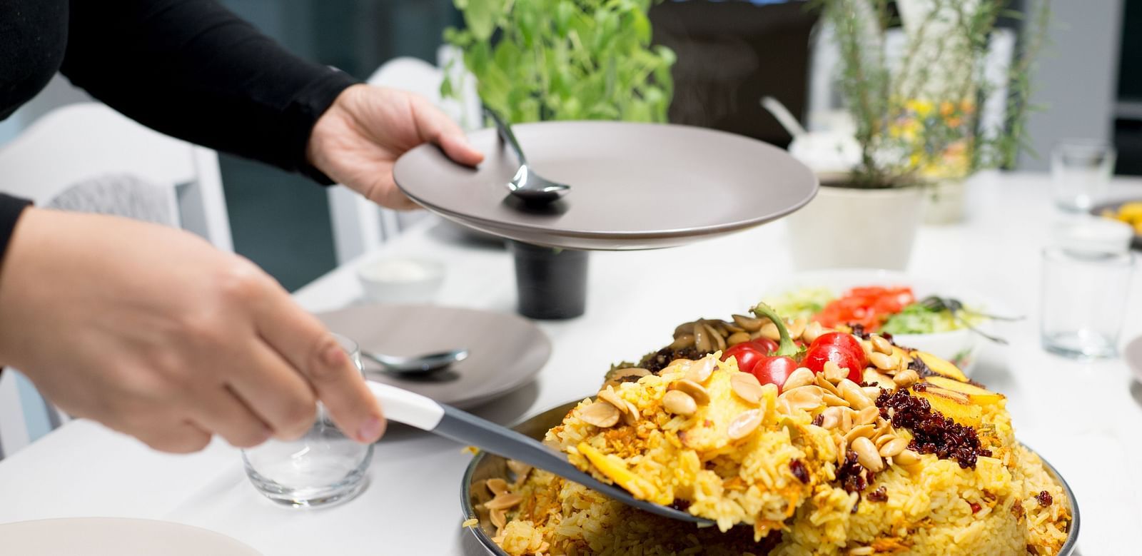A person serving a freshly cooked meal at a dinner tale set for guests at Sitara Luxury Hotel in Hyderabad near Ramoji Film City.