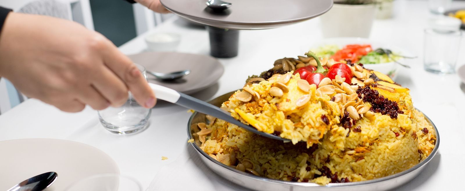 A person serving a freshly cooked meal at a dinner tale set for guests at Sitara Luxury Hotel in Hyderabad near Ramoji Film City.