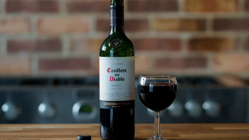 a bottle of wine and a glass kept on a table