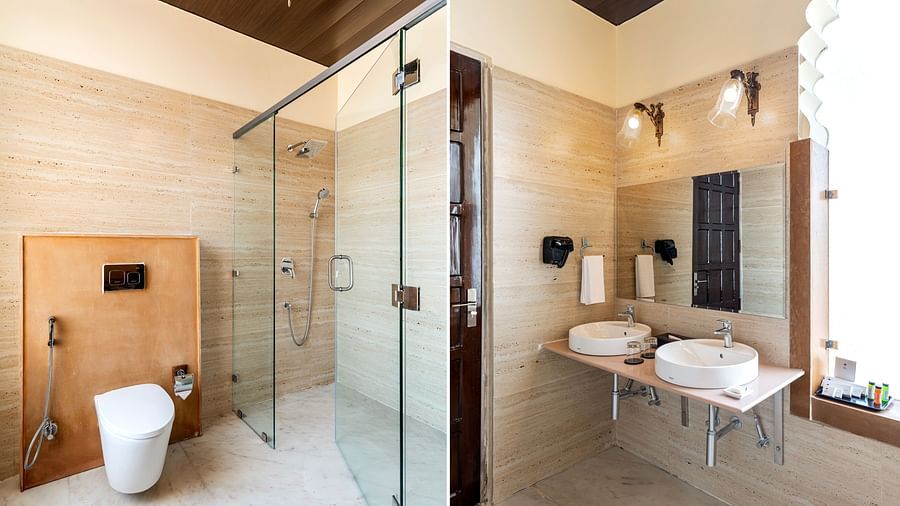 Spacious bathroom with glass shower, twin sinks, and golden lighting at Kesar Bagh Palace.