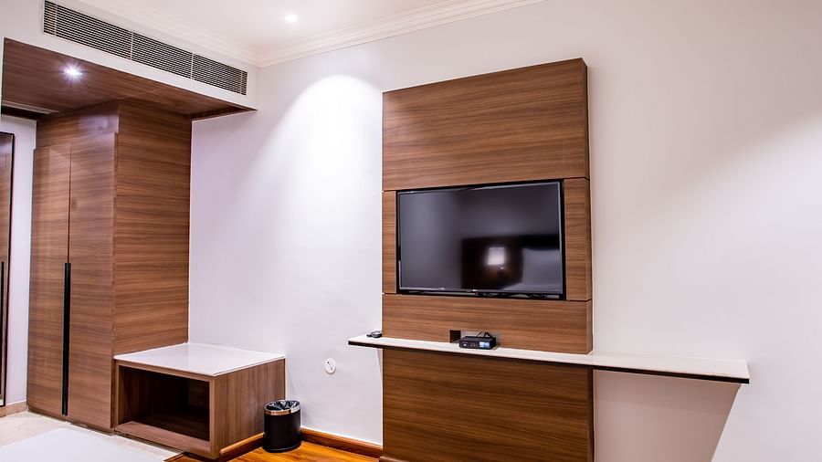 a view from the bed of the tv wall mounted inside one of the rooms - Wedlock Greens Hotel Resorts Dhanbad
