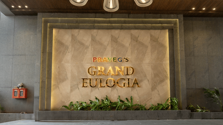 The elegant gold-lettered entrance signage of Praveg's Grand Eulogia under modern architectural lighting.