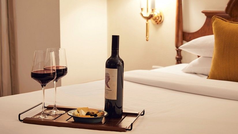 a bottle and two glasses of wine on a bed 21