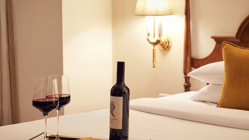 a bottle and two glasses of wine on a bed 21