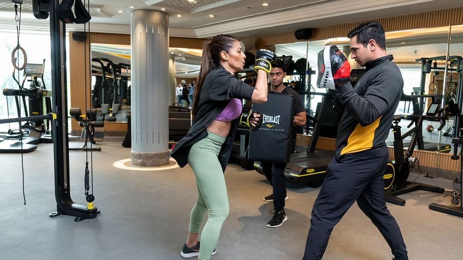An image of a woman practising boxing with trainers - The Claridges New Delhi