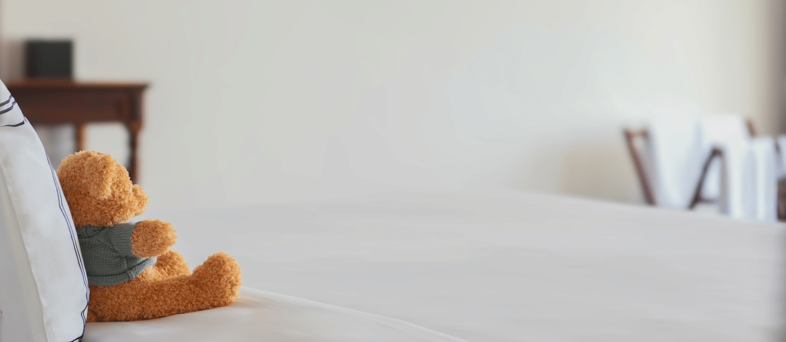 Executive Ocean Suite at Alibu Resort Nha Trang, Vietnam, with king bed, white linens, side table, lamp, chair and bright natural light entering through the window.