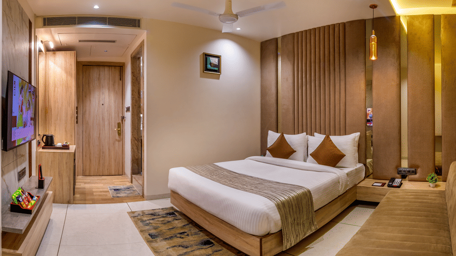 Room corridor at Lords Inn Sangam, Bhopal with polished marble flooring, warm ceiling lighting, and neatly numbered wooden room doors.