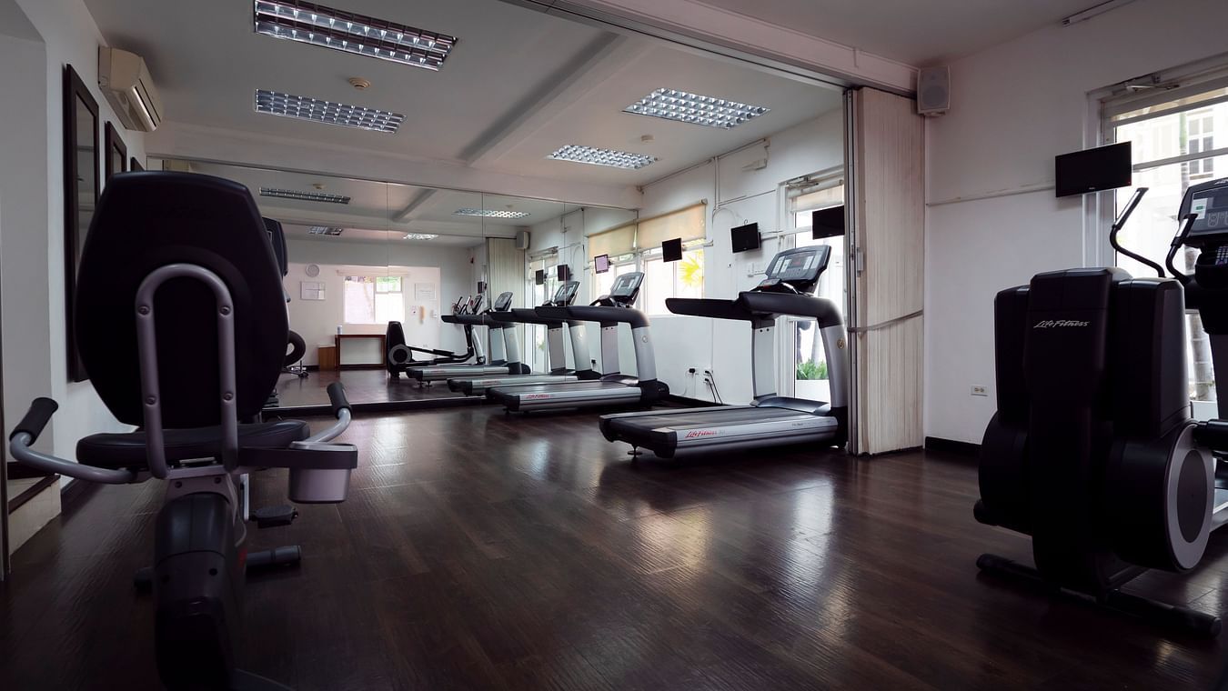 Spacious gym with various workout equipment and mirrored walls - S Hotel Kingston, Jamaica
