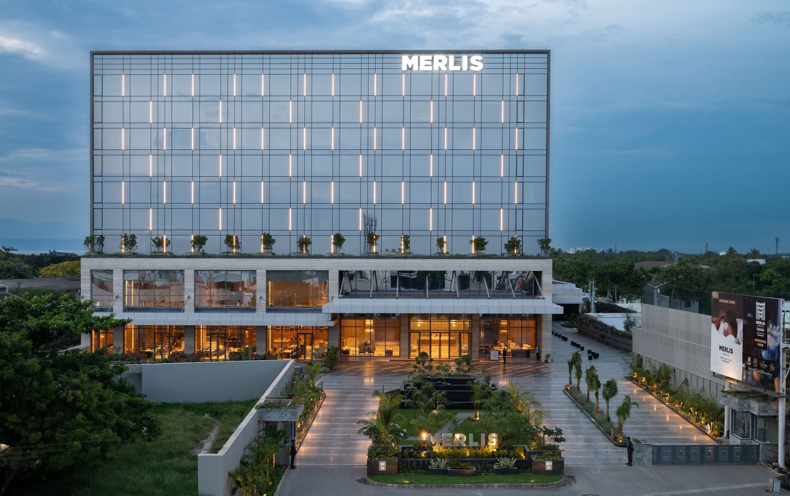 Full exterior view of the hotel building during twilight, showcasing its modern design at Merlis Hotel, the best 5-star hotel in Coimbatore.