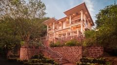 The building where our hotel offers dining facility surrounded by lush green trees - Highland Sarovar Portico, Sindhudurg