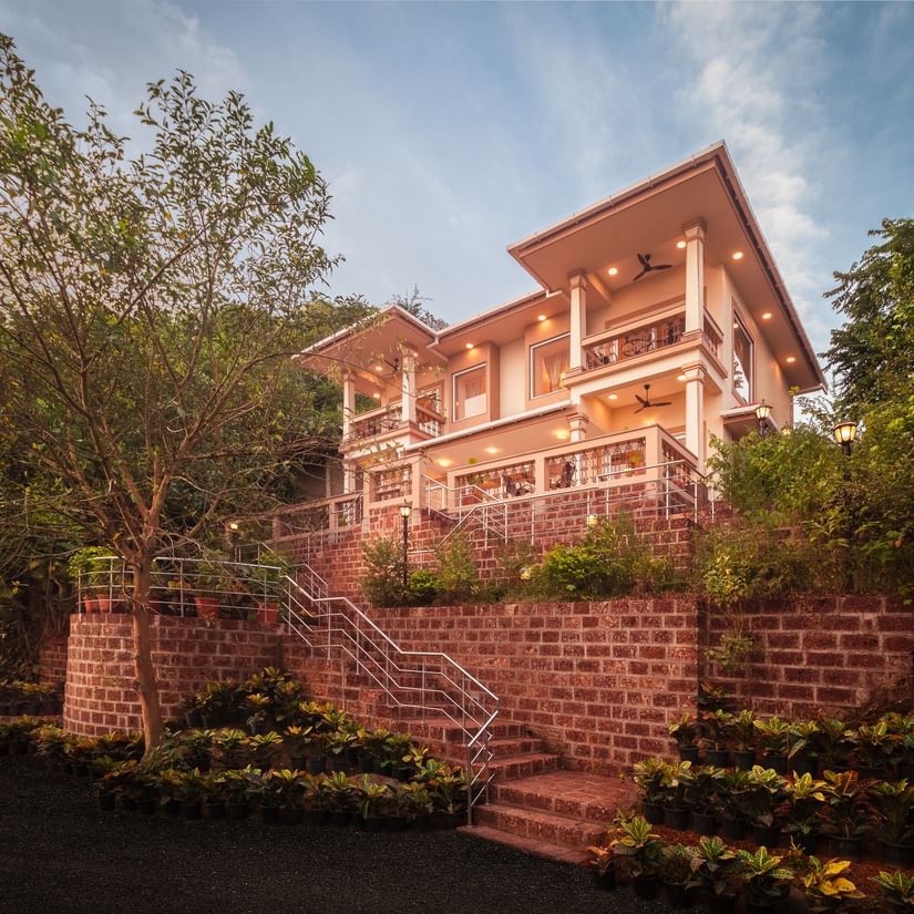 The building where our hotel offers dining facility surrounded by lush green trees - Highland Sarovar Portico, Sindhudurg