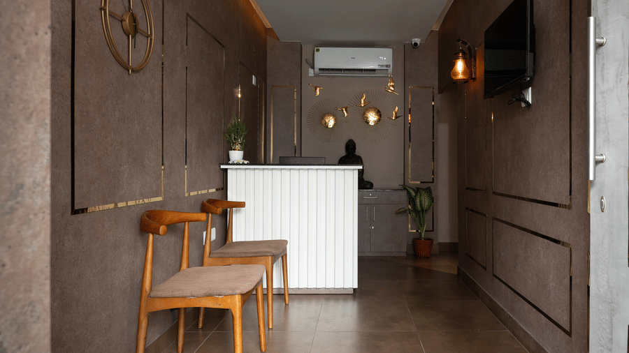 Spa area with a front desk, a bench for seating, and a clock on the wall at Hotel Sonar Bangla, Taki.
