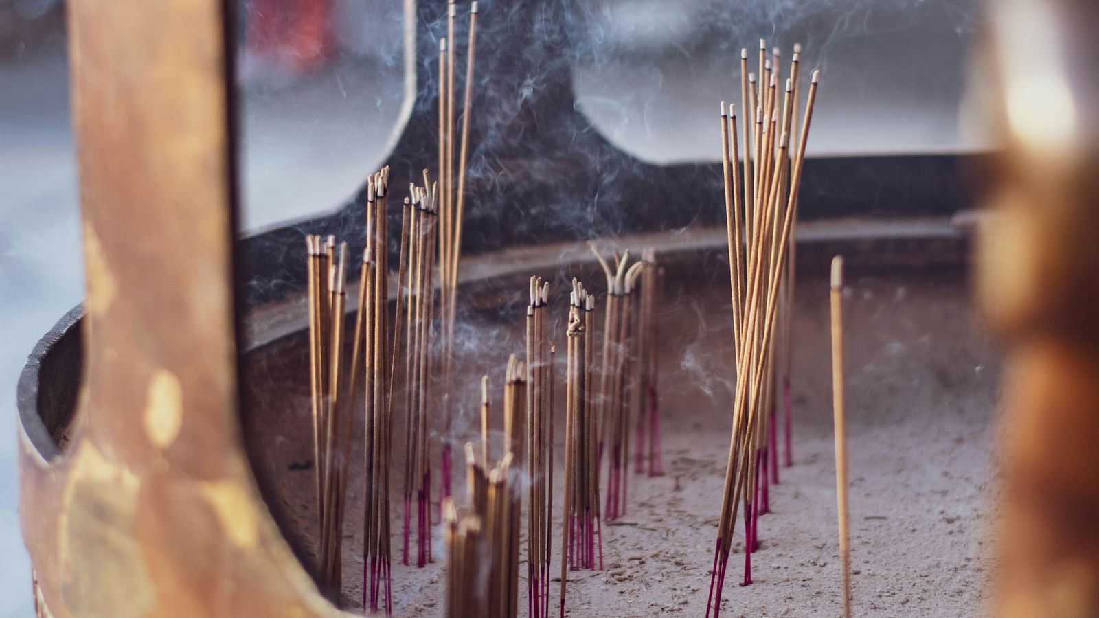 Brown incense sticks burning on a wooden concrete floor.