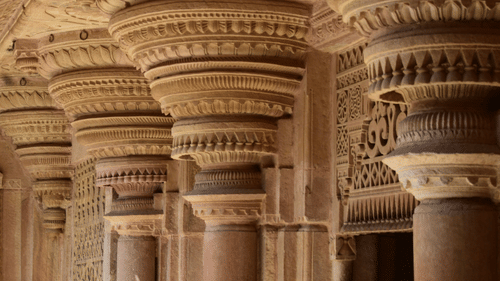 Ancient pillars of Man Mandir Palace within the Gwalior Fort featuring intricated details