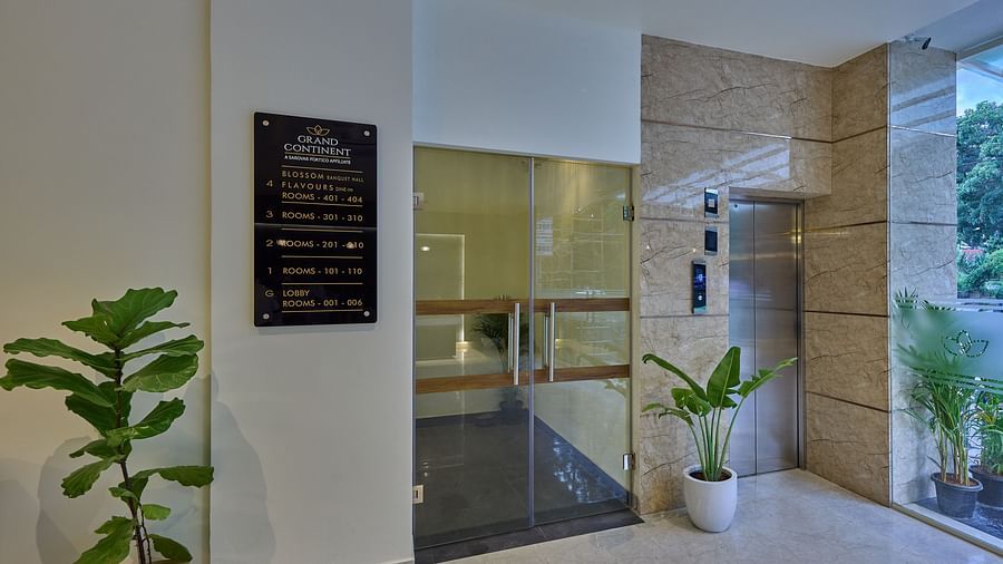 An image of an elevator in our hotel with a wall-mounted signboard beside the lift indicating the destinations of each floor