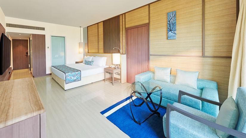 An image of a room with a bed, bed side tables, flat screen TV,  sofa set and a table - The Resort, Mumbai