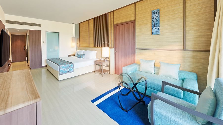 An image of a room with a bed, bed side tables, flat screen TV,  sofa set and a table - The Resort, Mumbai