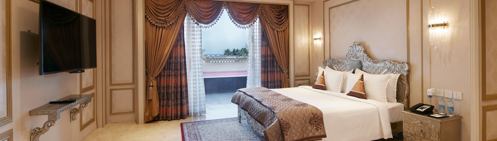 Bedroom with a regal gold-accented ceiling and a comfy double bed with red cushions - Kaldan Samudhra