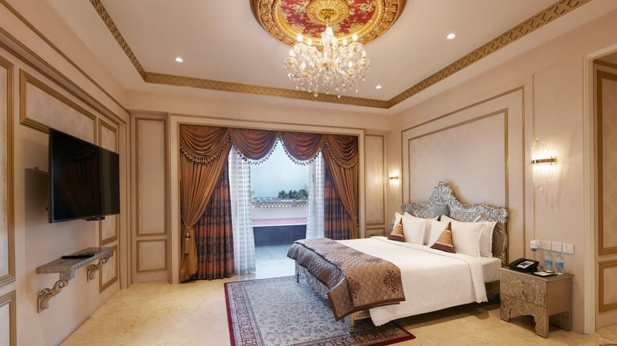 Bedroom with a regal gold-accented ceiling and a comfy double bed with red cushions - Kaldan Samudhra