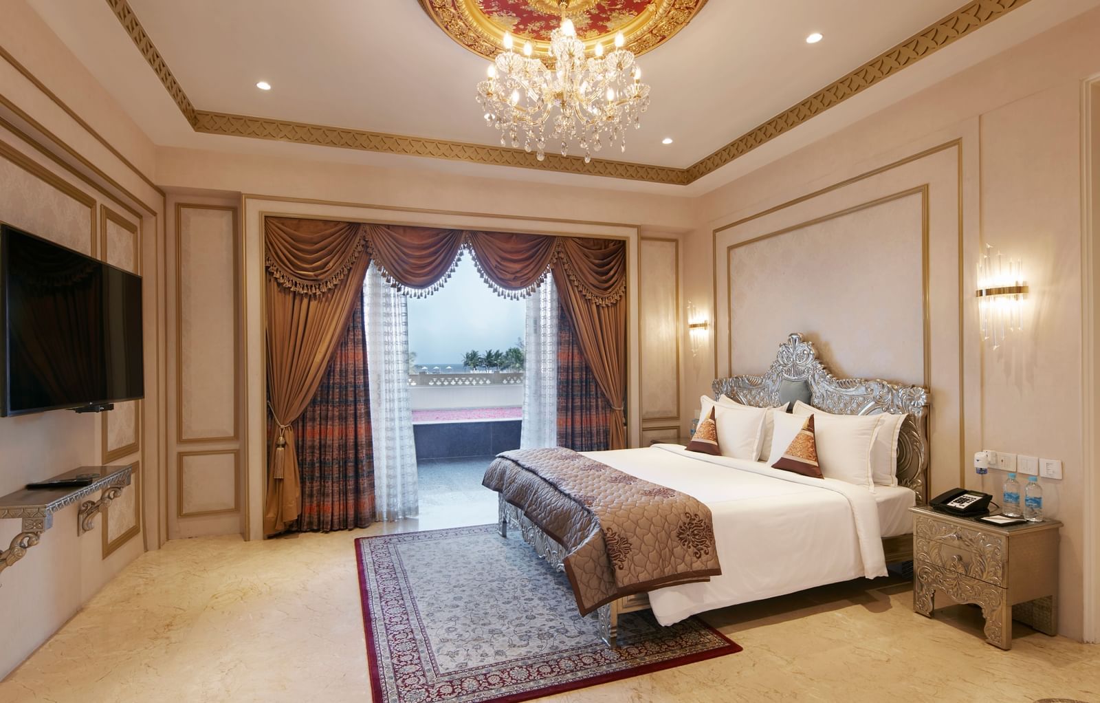 Bedroom with a regal gold-accented ceiling and a comfy double bed with red cushions - Kaldan Samudhra