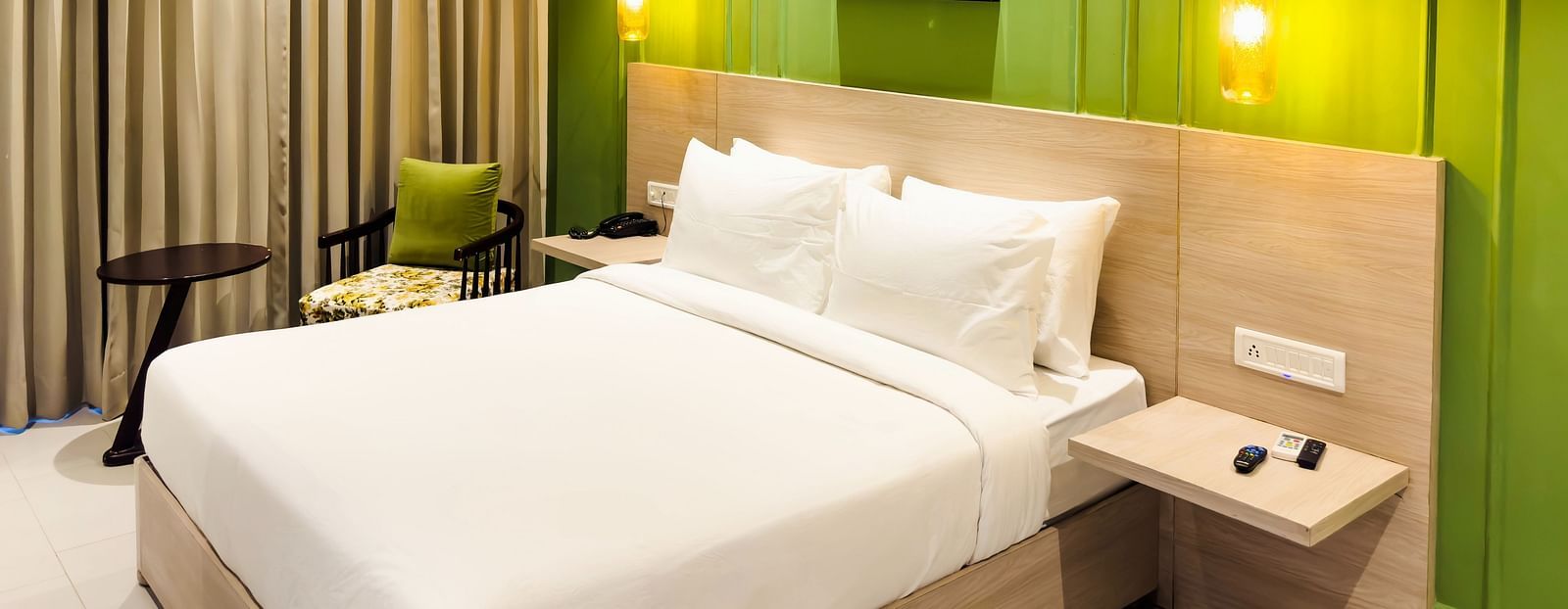 A view of the hotel room with a large bed, ambient light and comfortable furniture - Wonder Hills