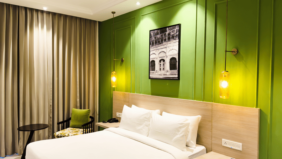 A view of the hotel room with a large bed, ambient light and comfortable furniture - Wonder Hills