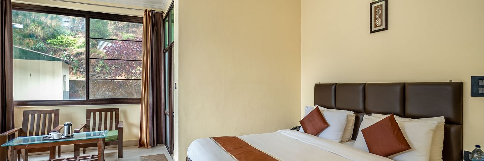 a plush bed overlooking a window at Flutter Hotels & Resorts