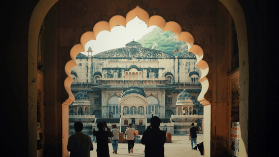 An arched doorway frames a view of a stone building.