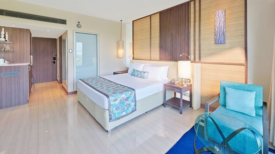 A bed and a sofa chair in a bedroom | The Resort