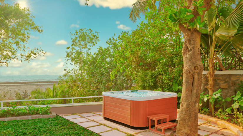 A jacuzzi placed near a tree with a view of the ocean as seen during the day at The Resort, Mumbai.