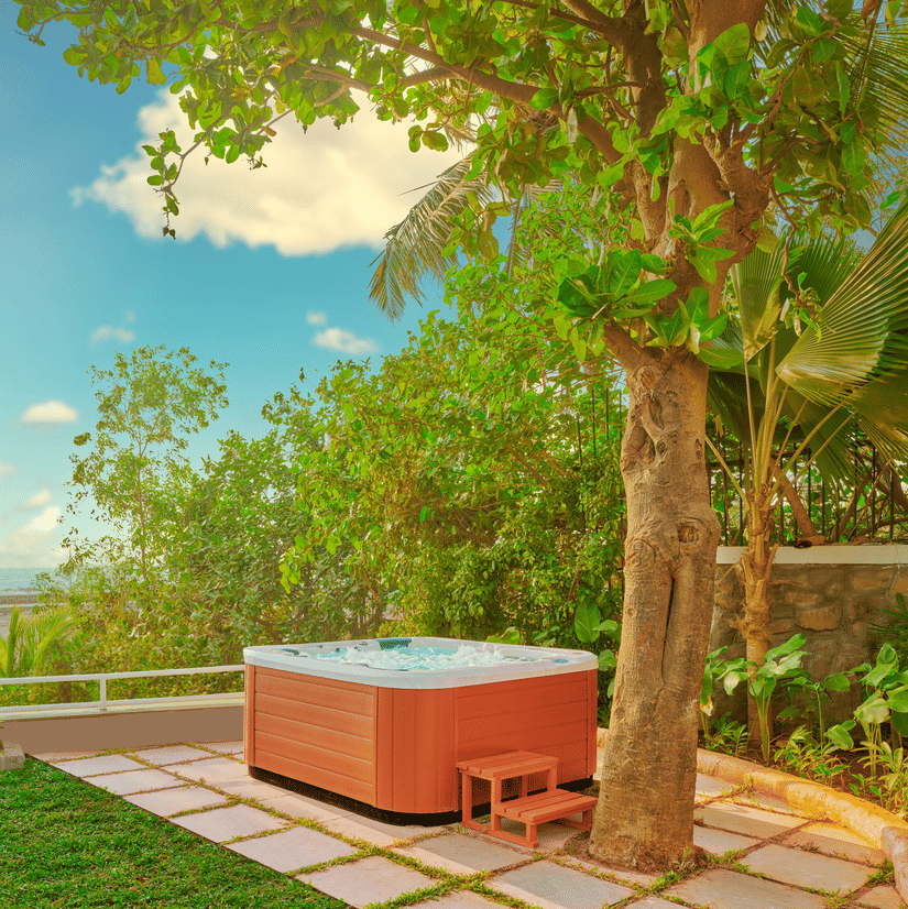A jacuzzi placed near a tree with a view of the ocean as seen during the day at The Resort, Mumbai.
