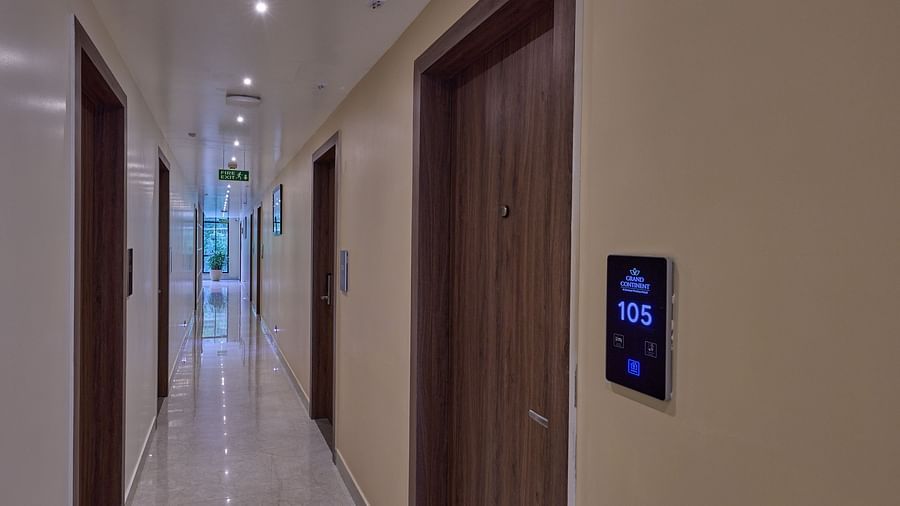 A corridor leading to the rooms in our hotel with wall-mounted electric sign boards representing the number of each room