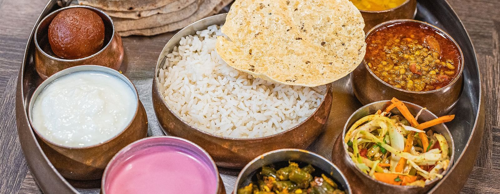 A traditional Indian thali meal served with various dishes at Lotus Leaf Boutique Hotel.