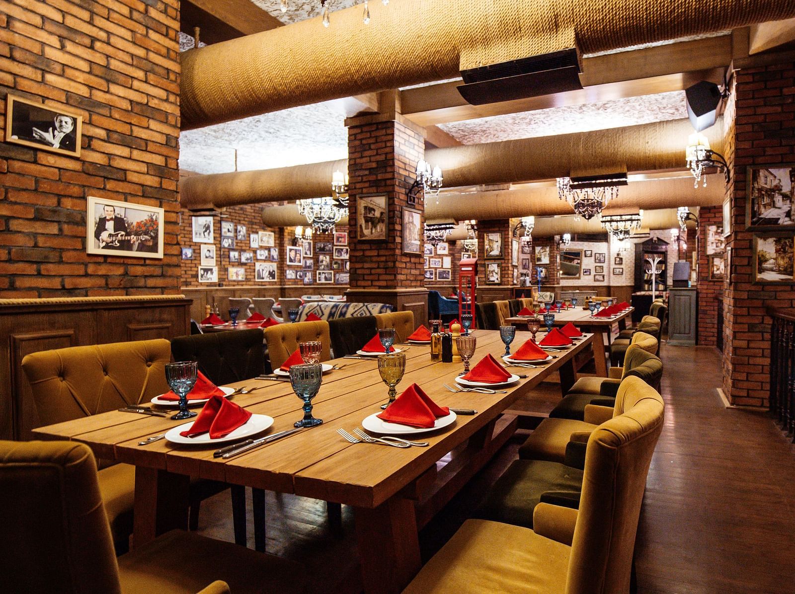 restaurant-hall-with-red-brick-walls-wooden-tables-pipes-ceiling