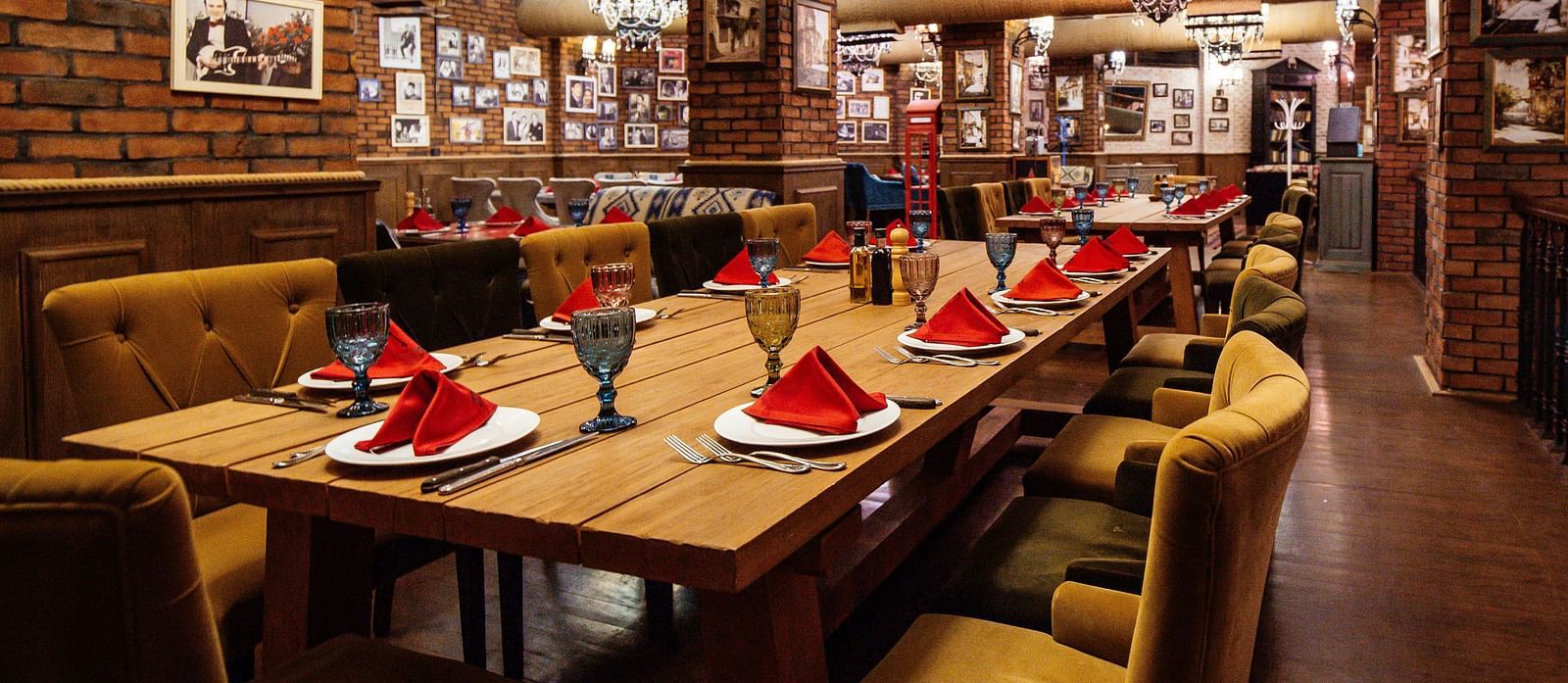 restaurant-hall-with-red-brick-walls-wooden-tables-pipes-ceiling