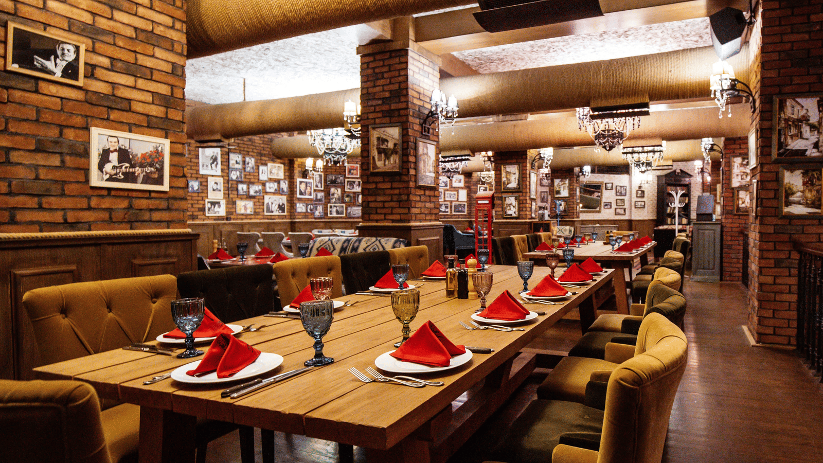 Corner view of the restaurant at Le ROI Jammu Hotel with well arranged cutlery on the table along with red napkins.