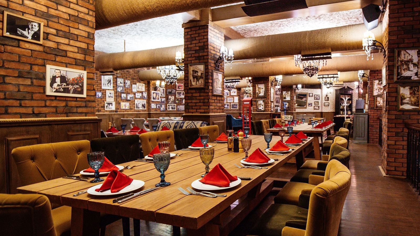 restaurant-hall-with-red-brick-walls-wooden-tables-pipes-ceiling