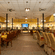 The Courtyard Restaurant at Featherlite Evoma Hotel with wooden seating, dark pillars and a wide dining hall spread throughout it.