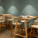 High table and bar stool seating set against a teal wall with pendant lighting at OJ Japanese Restaurant, Featherlite Evoma Hotel.